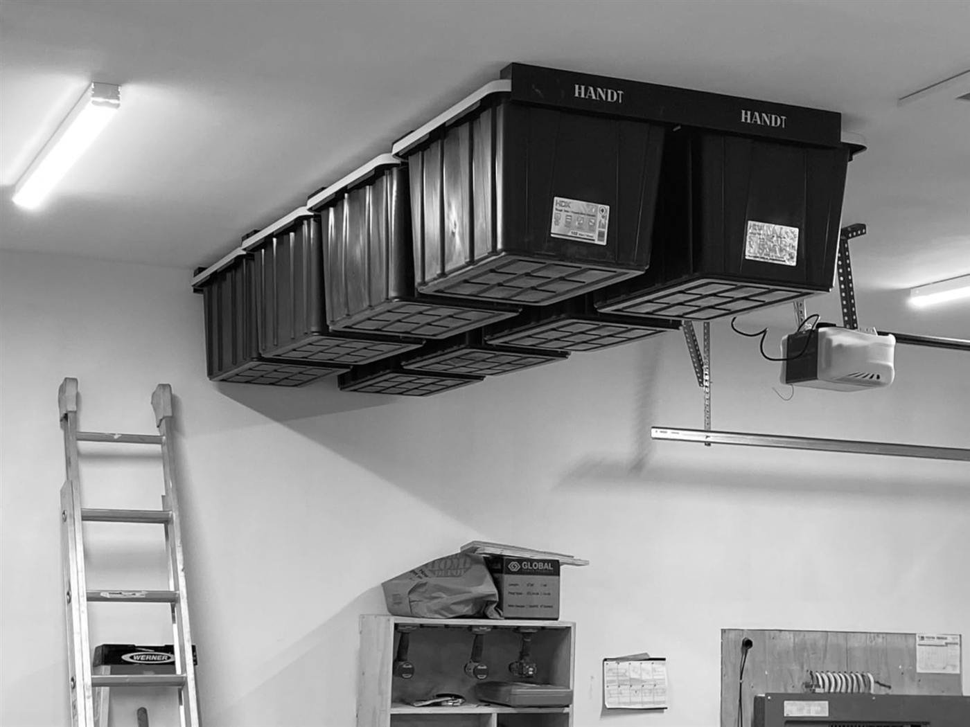 Matching black storage totes on an overhead ceiling rack